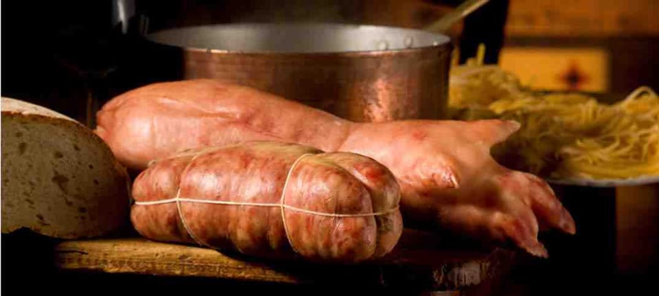 Zampone e cotechino affettati su un tagliere
