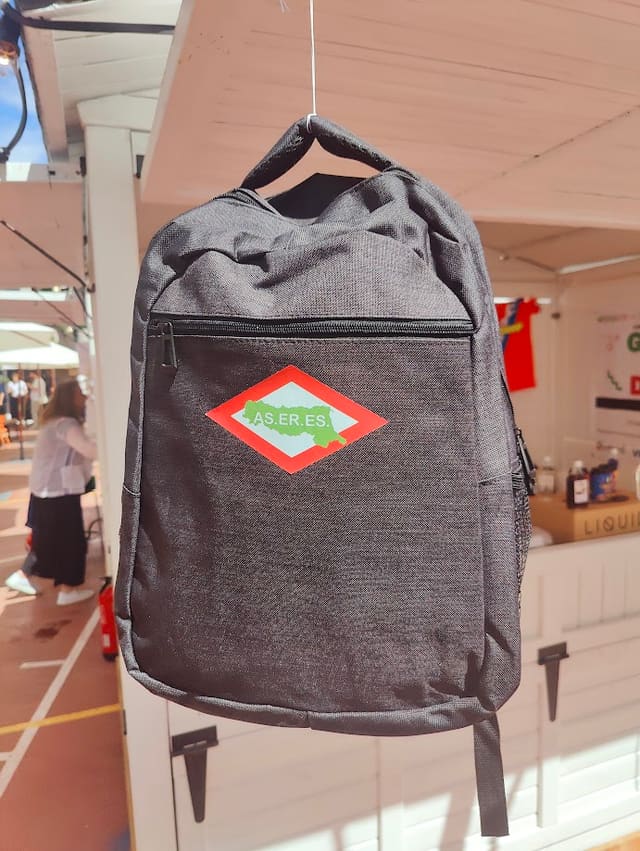 Mochila con el logotipo de AS.ER.ES. en el estand de la asociación en una feria