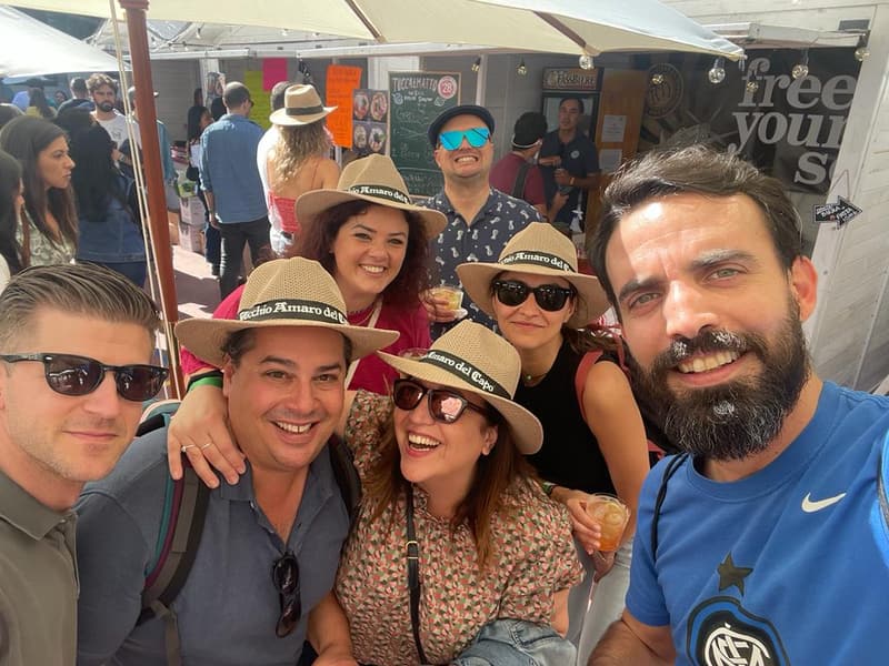 Socios y amigos de AS.ER.ES. sonriendo con sombreros de paja en una fiesta al aire libre