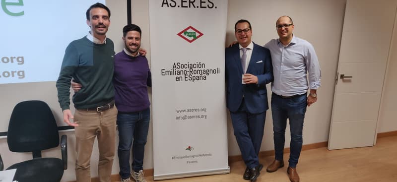 Miembros de AS.ER.ES. junto al roll-up de la asociación en una presentación